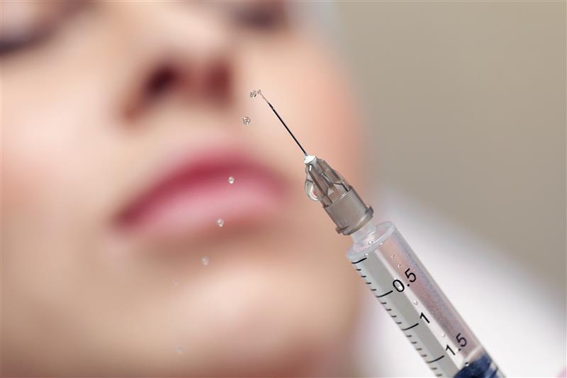 Close up of a needle giving an injection in a beauty salon